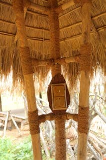 Natural timber posts supporting a thatched craft workstation roof