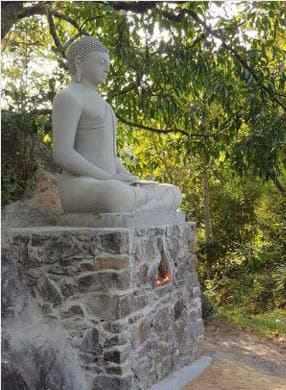 Seated Buddha statue rendered in earth-toned plaster